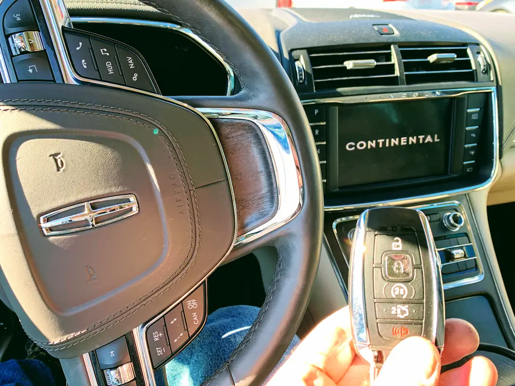 A Lincoln key fob being programmed inside a vehicle
